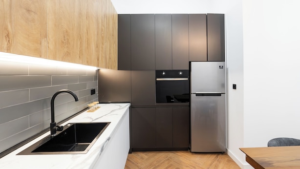 A modern kitchen with a stainless steel refrigerator, a built-in oven, and a sleek faucet. - Chic & Modern 4BR Home in Old Tbilisi (Tbilisi)