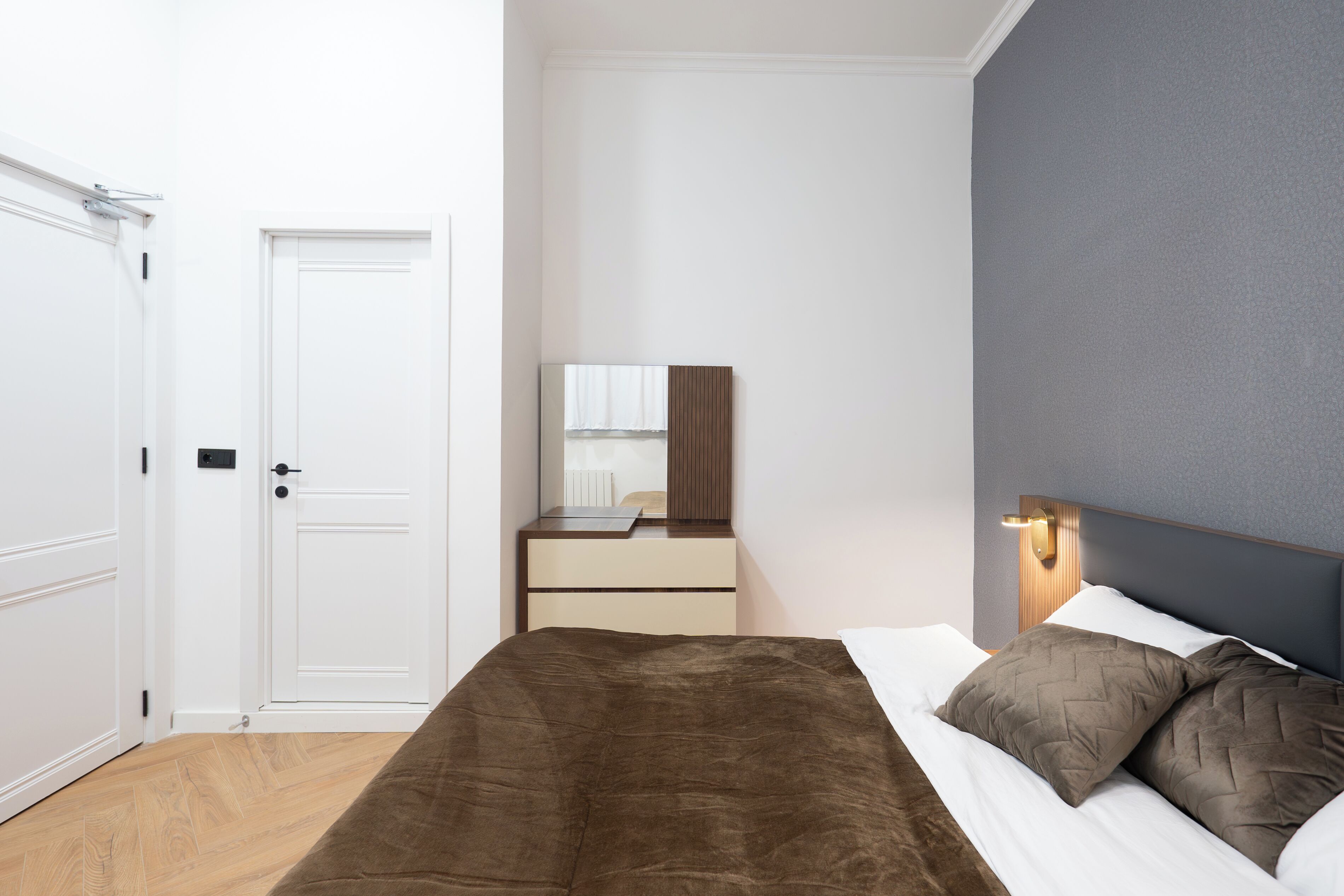 Un dormitorio con cama, cómoda, espejo y puerta.