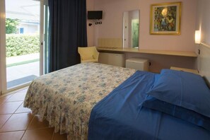 Eenvoudige eenpersoonskamer, uitzicht op tuin | Een kluis op de kamer, een bureau