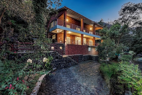 Vista frontal de la propiedad por la tarde o noche