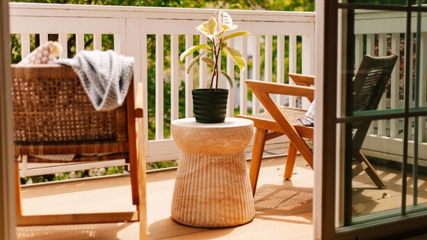 A wooden deck with wicker chairs, a small round table with a potted plant, and a glass door. - Downtown Saugatuck Dream (Saugatuck)