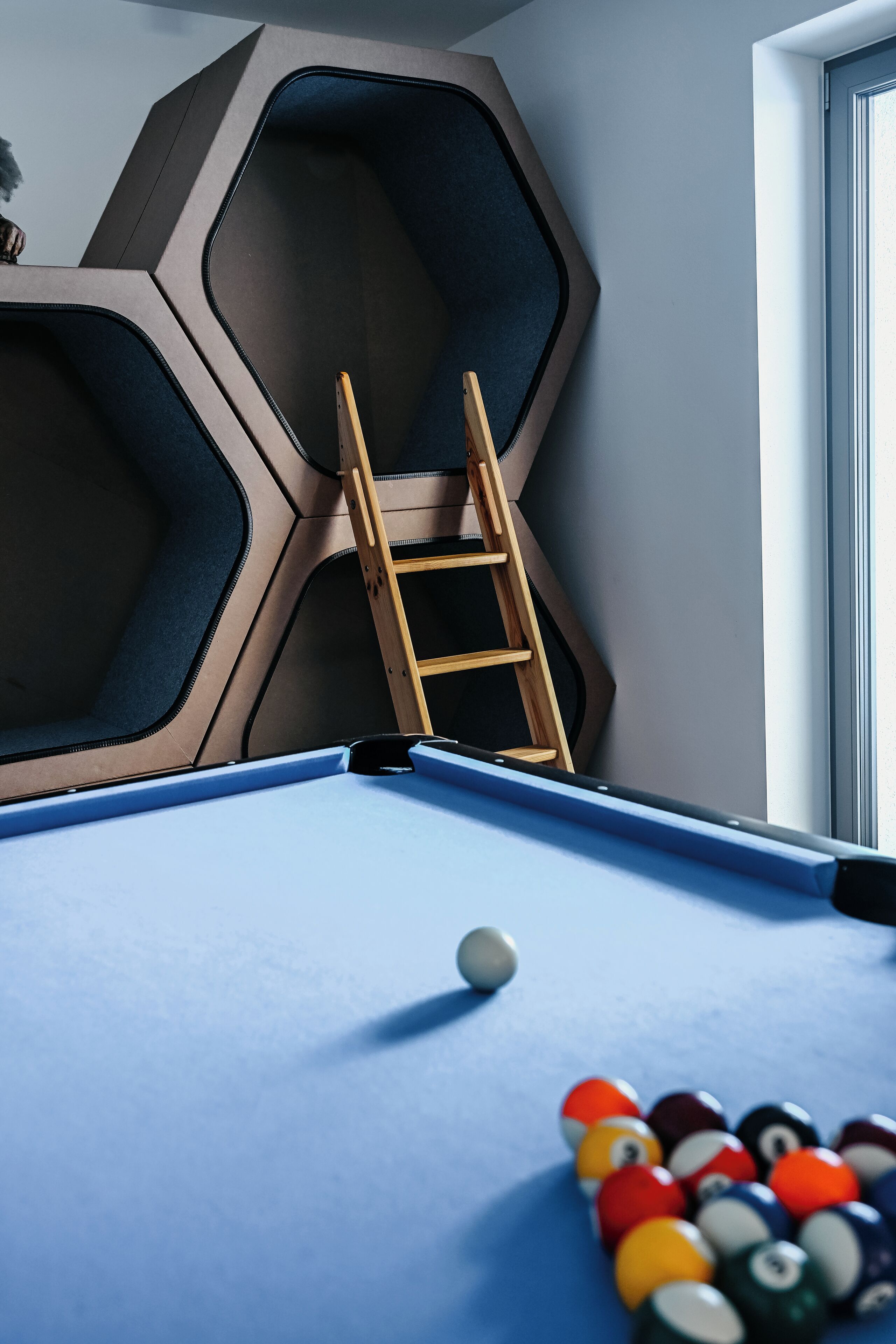 Een pooltafel met een blauwe viltkleed, een poolkeu en een set kleurrijke ballen.
