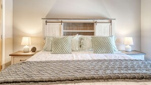 A bedroom with a bed, two bedside tables with lamps, and a headboard with storage. - Razorback Retreat – Walk to Stadium & Downtown (Fayetteville)