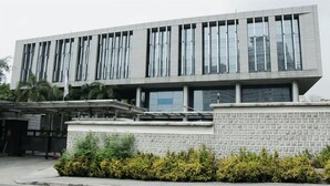 A modern building with a flat roof, large windows, and a brick base. - BGC McKinley Center Prime Accommodations (Taguig)