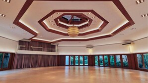 A spacious hall with a high ceiling, recessed lighting, and a central hanging light fixture. - BGC McKinley Center Prime Accommodations (Taguig)