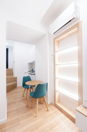 Een moderne keuken met witte kastjes, een houten aanrechtblad en een inbouwfornuis.