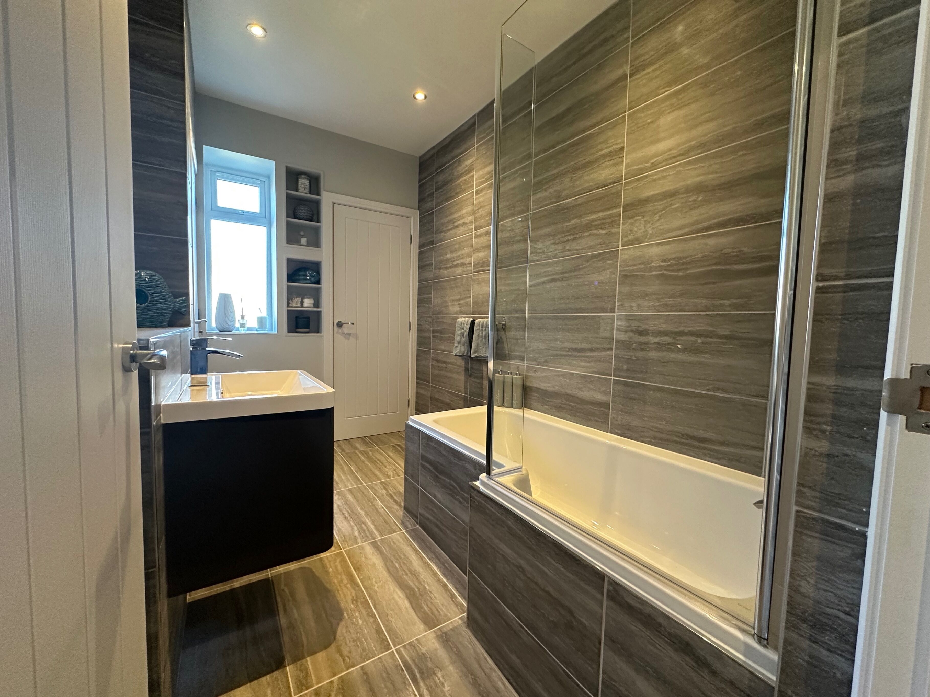 Une salle de bain moderne avec une baignoire, une douche à parois de verre et un meuble-lavabo.