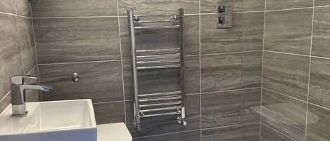 A modern bathroom with a shower, toilet, and sink.
