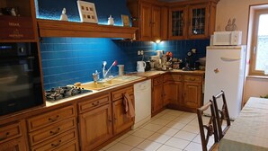 Una cocina con armarios de madera, un fregadero, una estufa y un refrigerador.