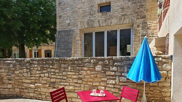 A stone building with a window and a blue umbrella. - Detached 50 m2 apartment in village house. (CAROMB)