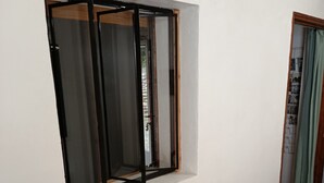 A room with a wooden table and chairs, a framed sign on the wall, and a window with a black frame. - Detached 50 m2 apartment in village house. (CAROMB)