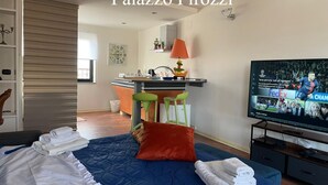 Ein Hotelzimmer mit Bett, Fernseher, Schreibtisch und Stuhl.
