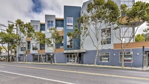 A modern building with a sign for "Key Route Lofts" and a "Sunday" sign on the left. - Romantic Plant filled studio Beautiful vibes! Spa Services Available (Emeryville)