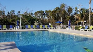 Una piscina con sillas de descanso y sombrillas.