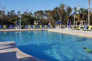 A swimming pool with lounge chairs and umbrellas. - Ocean View Treehouse Double King Suite 3403 (Tavernier)