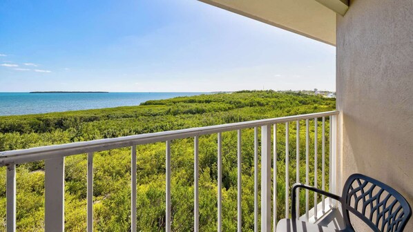 A balcony with a view of the sea and dense greenery. - Ocean View Treehouse | 2 Kings | Ocean Pointe 3403 (Tavernier)