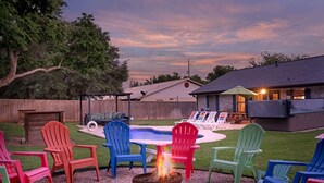 A backyard with a fire pit, outdoor seating, a pool, and a barbecue area. - Boho Bougie: Pool, Hot Tub & Epic Back Yard (Fredericksburg)