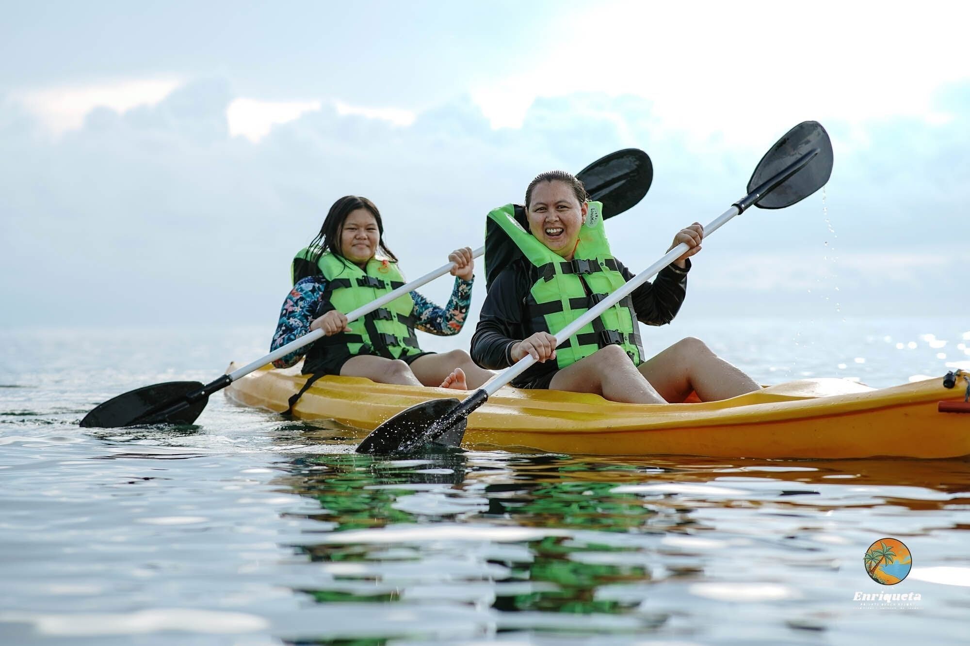 Deux personnes pratiquent le kayak sur une étendue d’eau calme.
