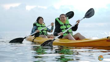 Deux personnes pratiquent le kayak sur une étendue d’eau calme.