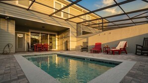 A swimming pool with a covered patio area, outdoor seating, and a view of the sky. - Family-Friendly 5BR with BBQ & Resort Perks (Clermont)