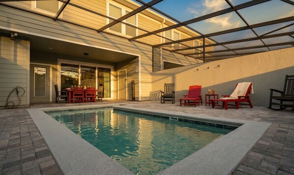 A swimming pool with a covered patio area, outdoor seating, and a view of the sky. - Family-Friendly 5BR with BBQ & Resort Perks (Clermont)