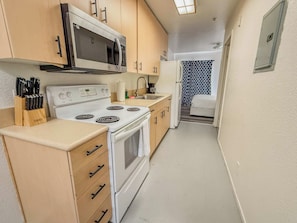 A compact kitchen with a stove, microwave, and sink. - 306 San Diego Downtown Loft Apartment / Parking (San Diego)