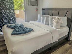 A neatly made bed with a grey headboard, white bedding, and a blue towel. - 306 San Diego Downtown Loft Apartment / Parking (San Diego)