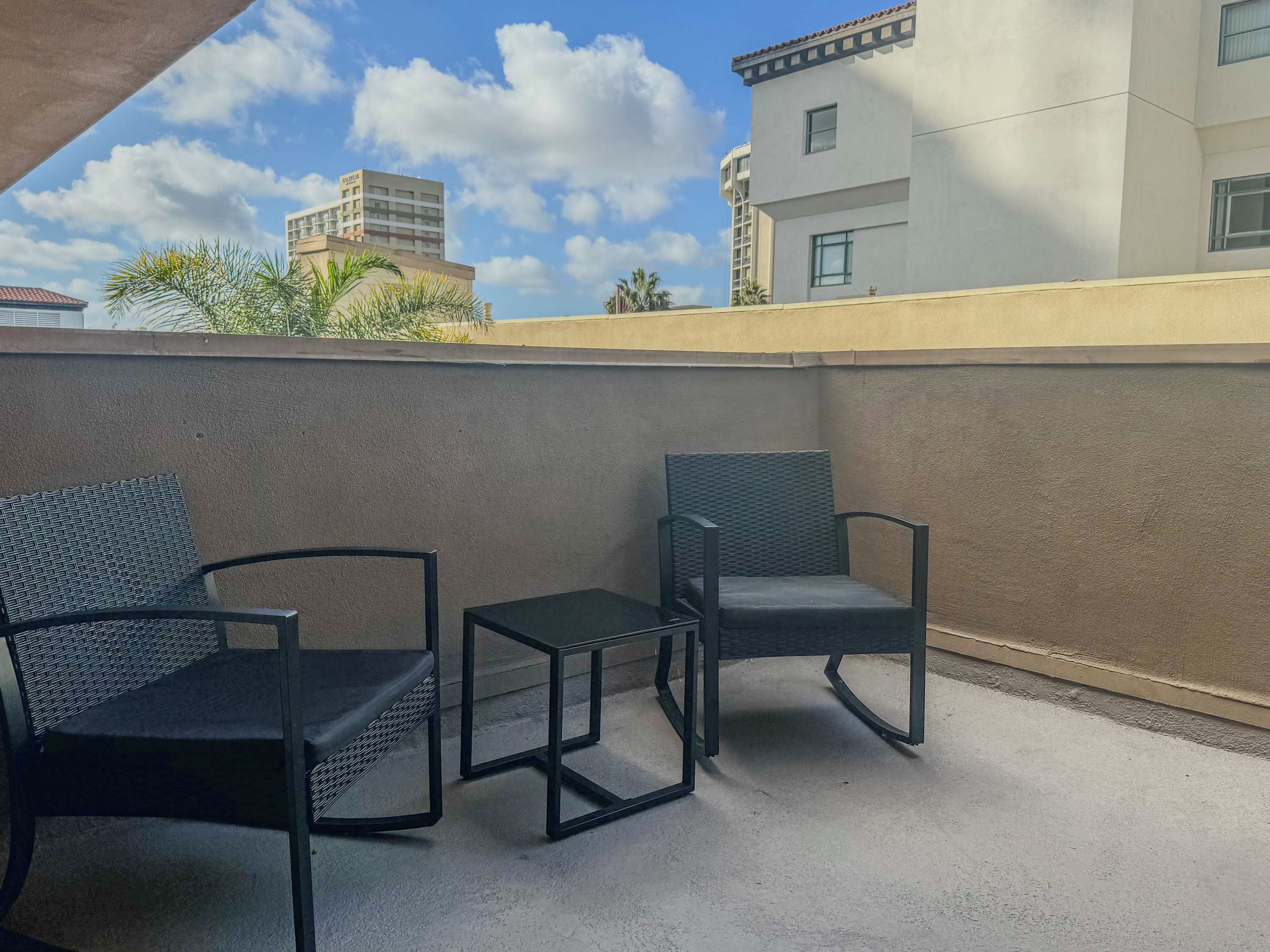 Een balkon met twee stoelen en een tafeltje.