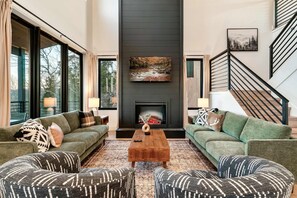 Relax in this stylish living room with a fireplace, sofas, and a large flat-screen TV.