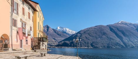 Una banchina in pietra con edifici, una panchina e un lampione.
