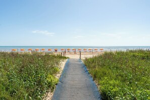 A beach path leading to beach umbrellas.