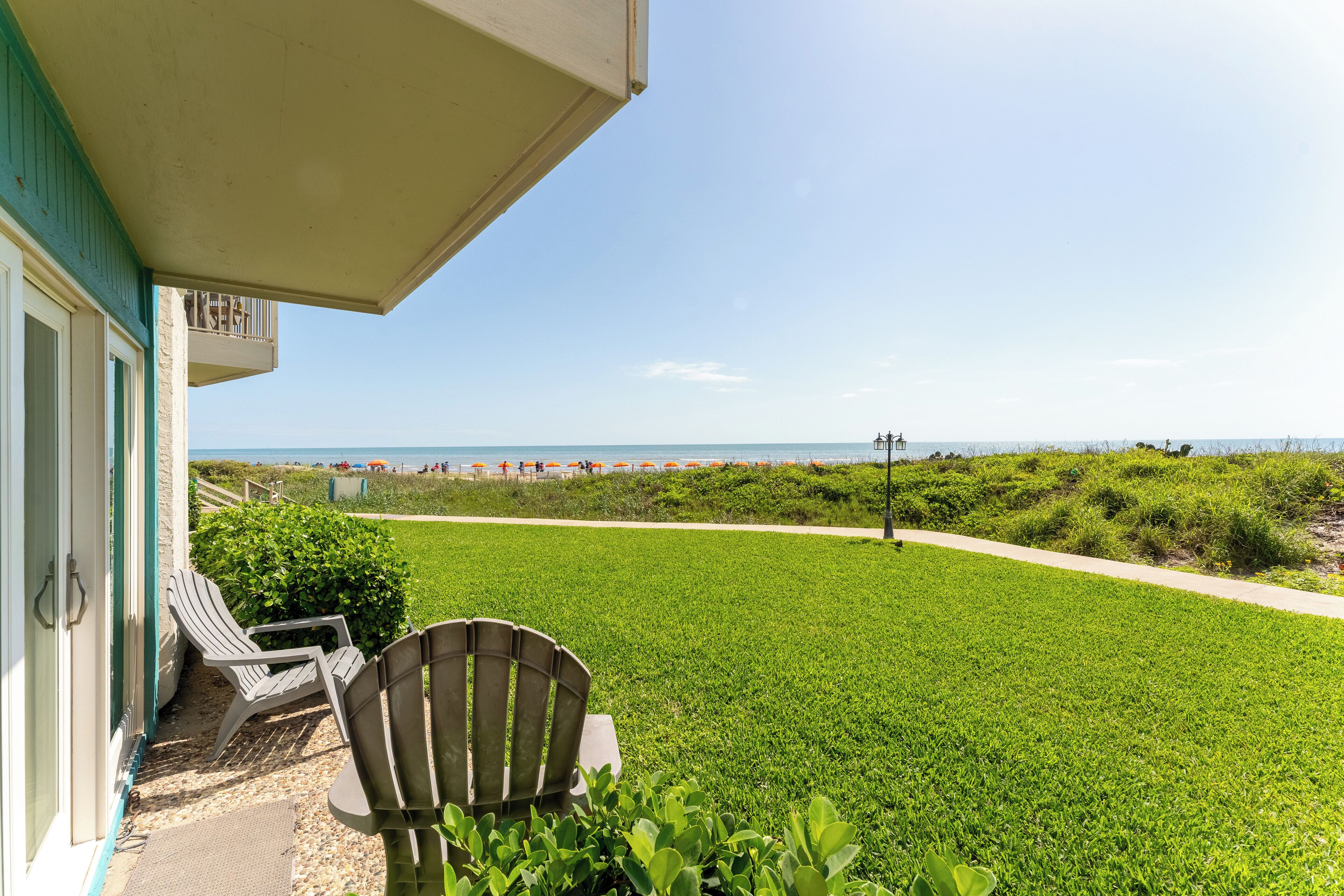 Eine begrünte Fläche mit Blick auf Strand und Meer.