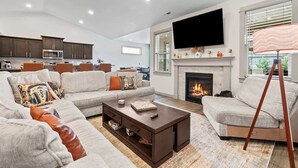 A modern living room with a fireplace, a large flat-screen TV, and a cozy seating area. - A Motown-Inspired Vinyl Retreat (Meridian)