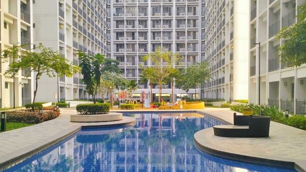 Una piscina rodeada por un edificio de gran altura con varios balcones.