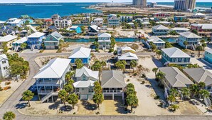 Un área residencial costera con casas, una playa y vistas al océano.