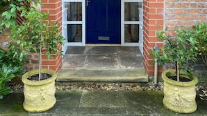 A brick building with a blue door, a white-framed entrance, and a small porch. - Fabulous unique accommodation within walking distance of Nantwich town centre (Nantwich)