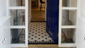 A doorway with a blue door, white-framed glass panels, and a checkered floor pattern. - Fabulous unique accommodation within walking distance of Nantwich town centre (Nantwich)