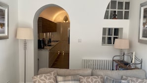 A living room with a sofa, lamps, and a view into the kitchen. - Fabulous unique accommodation within walking distance of Nantwich town centre (Nantwich)