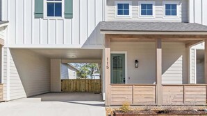 Une maison à deux étages avec un garage fermé et un jardin devant.