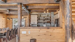 Un interior de madera con comedor, cocina y bar.