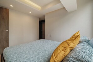 A bedroom with a bed, a wooden door, and a closet.
