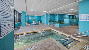 An indoor spa with a shallow water pool, a no diving sign, and a caution sign advising on health considerations. - LA74 Great studio right on the beach + pool (Myrtle Beach)