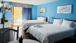 A hotel room with two beds, a desk, and a chair. There are two paintings on the wall, a window with curtains, and a ceiling vent. - SM50 Bright Studio walk to the beach (Myrtle Beach)