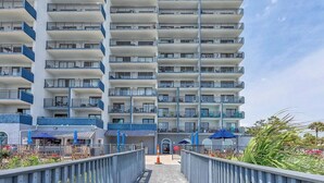 A multi-story hotel with balconies, a covered entrance, and outdoor seating. - Blue Water Resort #19 great studio on the beach! (Myrtle Beach)