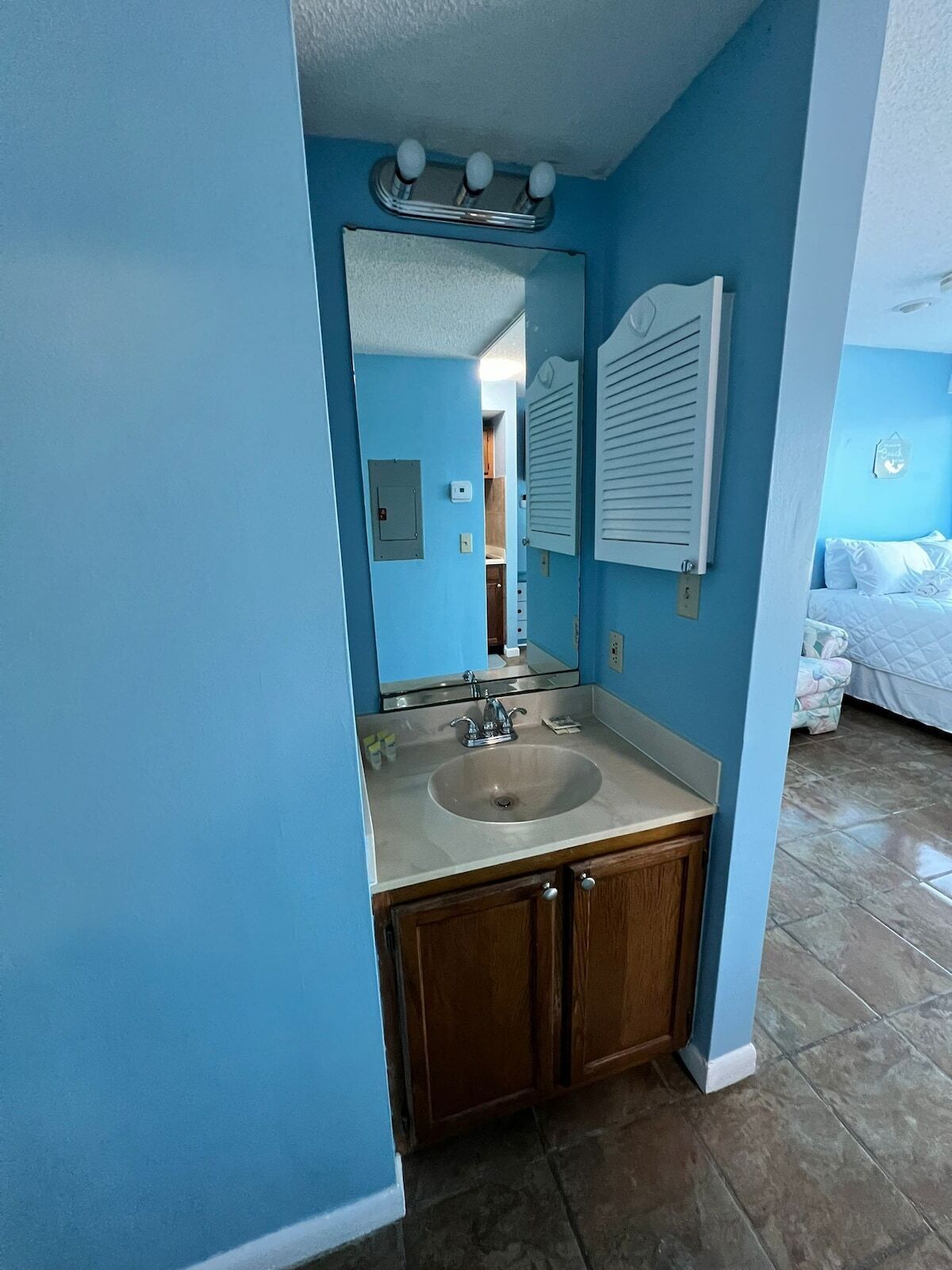 A bathroom with a sink, mirror, and a towel rack.