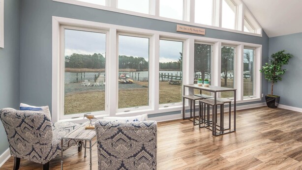 A room with large windows, a dining table, two patterned chairs, and a potted plant. - Grays Inn Creek Waterfront Pvt Dock Kayaks & View (Rock Hall)