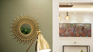 A room with a modern decor, including a sunburst mirror and a table set for dining. - Xuru Stays I Play Foosball & Do Yoga - 1 BR Apt. 5 Min To Airport (Cairo)