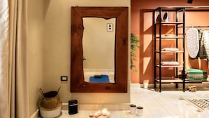 A hotel room with a blue exercise mat, a wooden-framed mirror, a shelf with towels, and a small plant. - Xuru Stays I Play Foosball & Do Yoga - 1 BR Apt. 5 Min To Airport (Cairo)