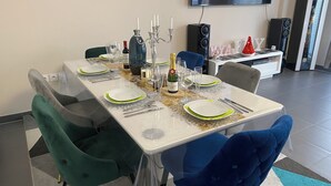 A dining table set with plates, cutlery, glasses, and a bottle of champagne. - Charming, cosy room just 5 minutes from Lille (Marcq-en-Barœul)
