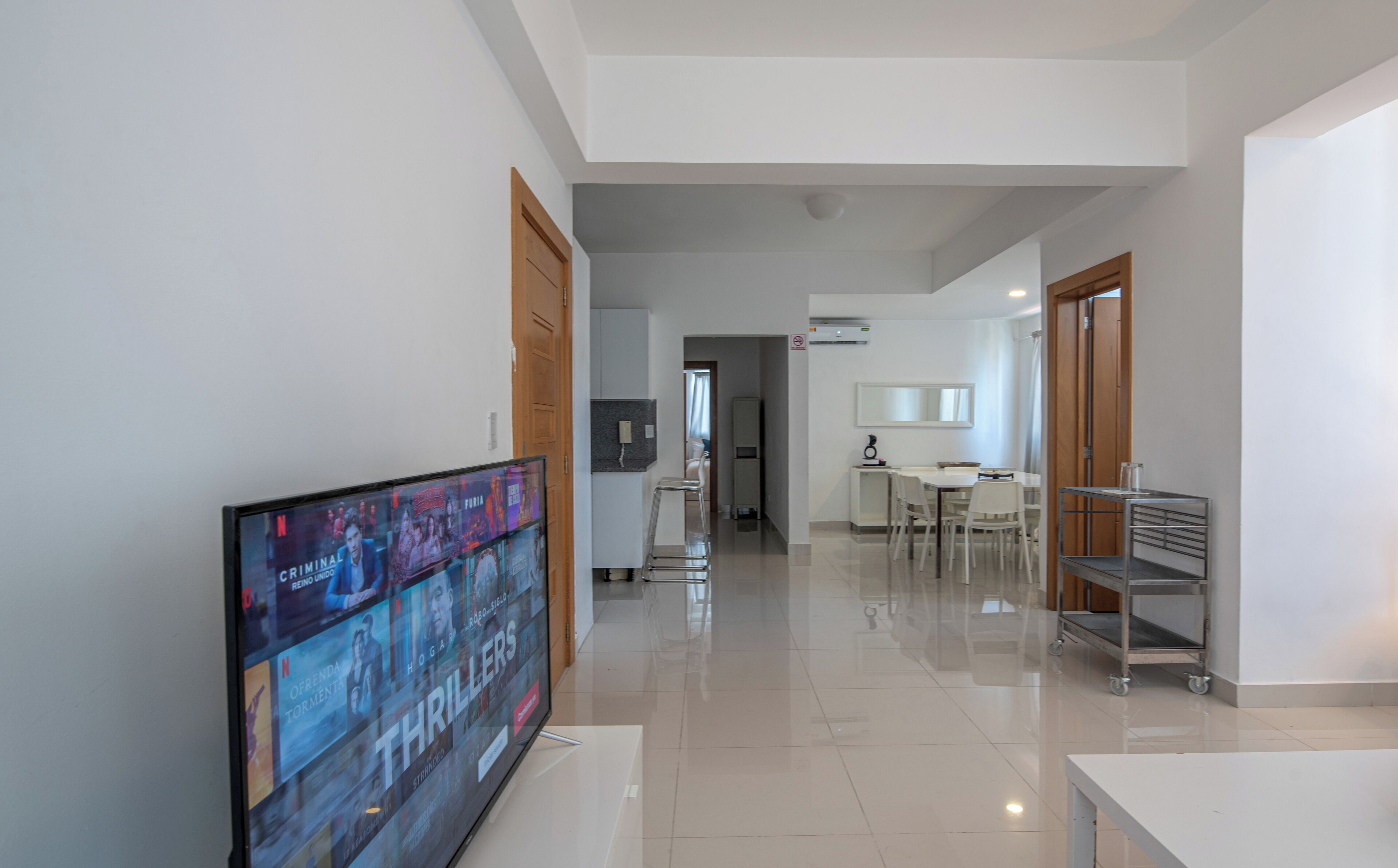 Un pasillo moderno de hotel con un televisor de pantalla plana mostrando una película.